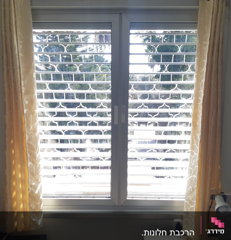 חלון עם תריסי אלומיניום לבנים